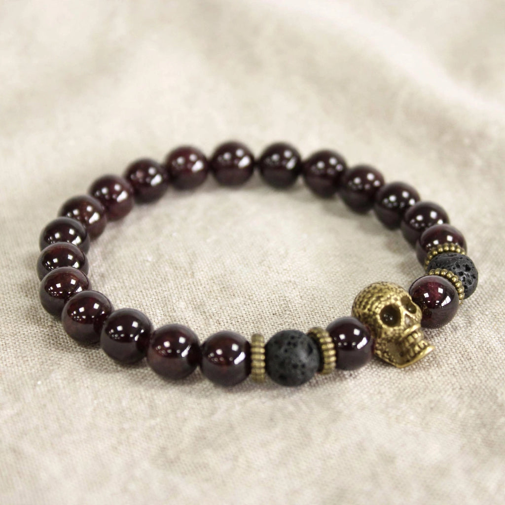Pulsera Renacer – Granate y Calavera Dorada