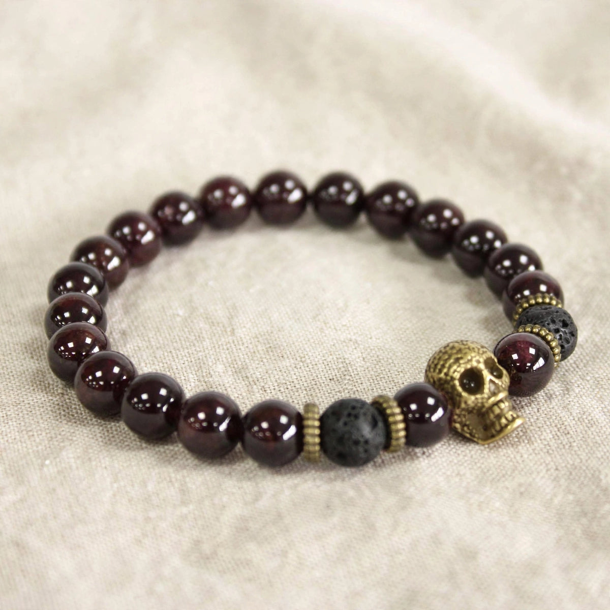 Pulsera Renacer – Granate y Calavera Dorada